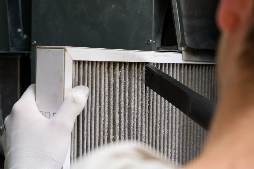 technician inspecting furnace to decide repair or replacement in Edmonton home